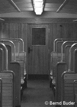Drehtür des Dienstabteiles: Gut erkennbar die sich im Fahrgastraum befindlichen Türscharniere. Der schwarze Punkt rechts ist der in die Wand eingelassene Türstopper (1984).